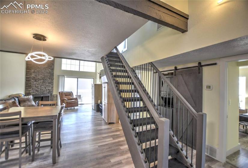 Stairway featuring a fireplace, a barn door, a textured ceiling, and light hardwood / wood-style flooring