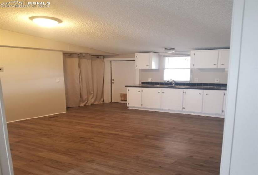 Kitchen with white cabinetry and dark hardwood / wood-style flooring