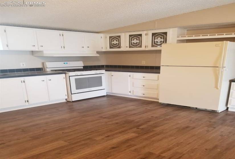 Kitchen featuring white appliances, dark hardwood / wood-style floors, and white cabinets