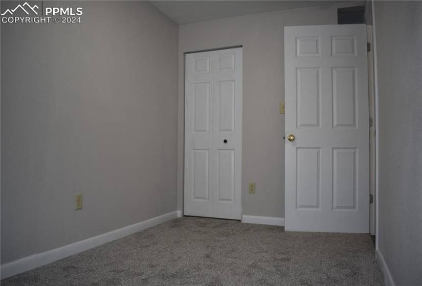 Unfurnished bedroom with dark colored carpet and a closet