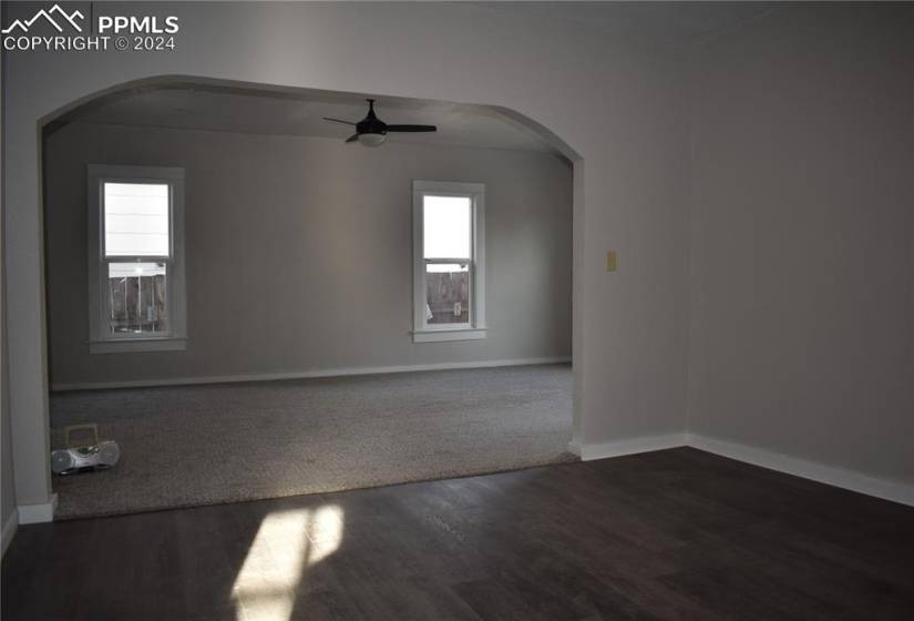 Spare room with dark hardwood / wood-style floors, ceiling fan, and a healthy amount of sunlight