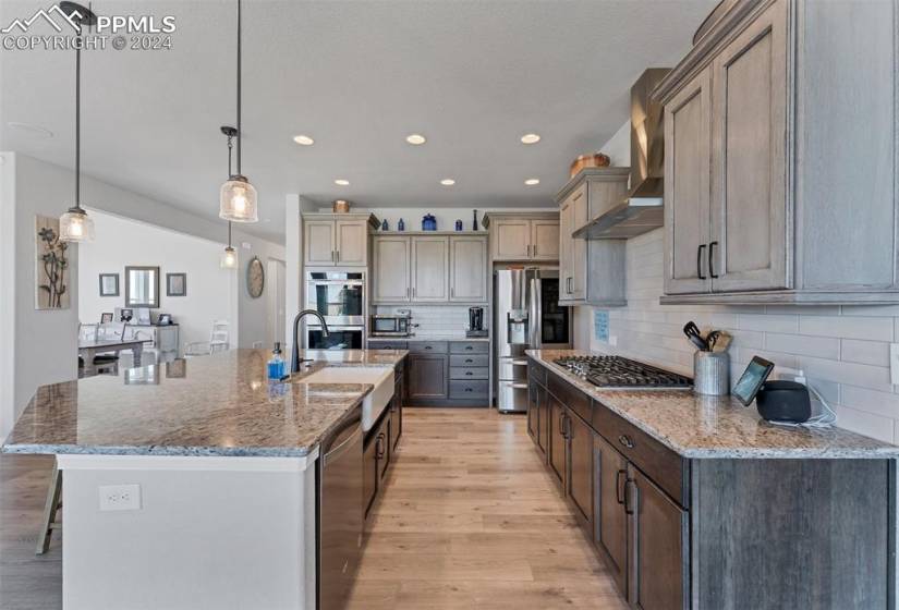 Kitchen featuring a textured ceiling, stainless steel appliances, light hardwood / wood-style floors, and gray cabinets