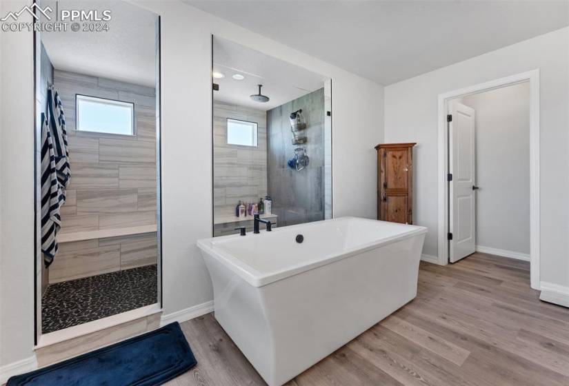 Bathroom with a washtub, a textured ceiling, and hardwood / wood-style floors