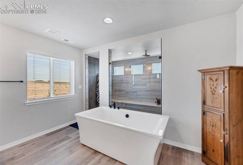 Bathroom with a washtub, a textured ceiling, and hardwood / wood-style floors