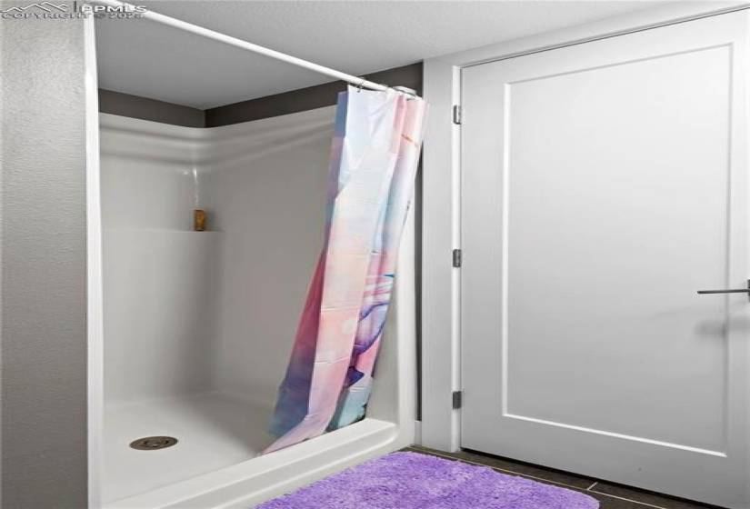 Bathroom featuring curtained shower and a textured ceiling