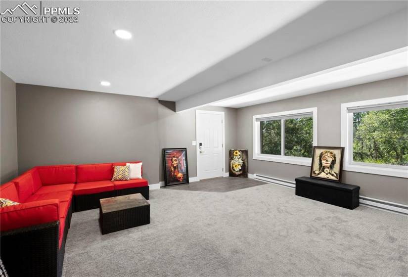 Living room featuring carpet flooring and a baseboard heating unit