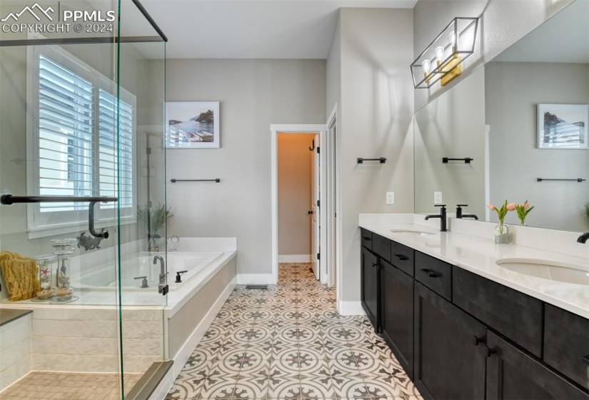 Bathroom featuring tile flooring, plus walk in shower, and double sink vanity