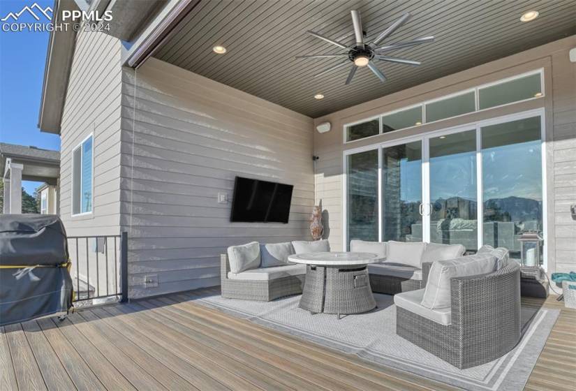 Deck with ceiling fan, grilling area, and an outdoor living space with a fire pit