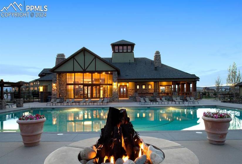 Pool at dusk featuring an outdoor fire pit and a patio