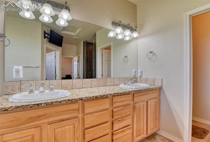 Bathroom featuring large vanity, dual sinks, and tile floors