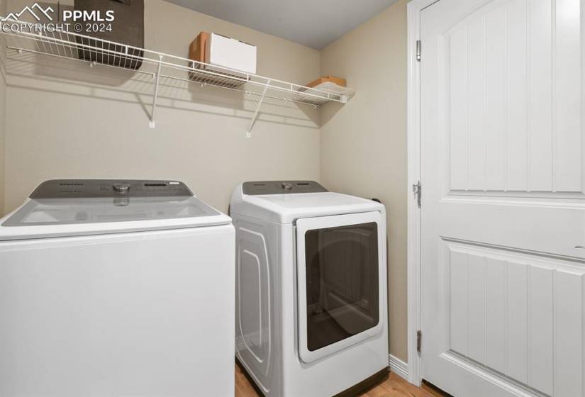 Laundry room featuring light wood-type flooring. Washing machine and clothes dryer included!