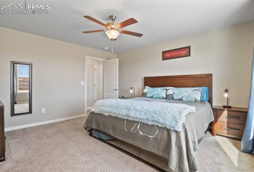 MAIN FLOOR primary suite with light neutral colors and ceiling fan
