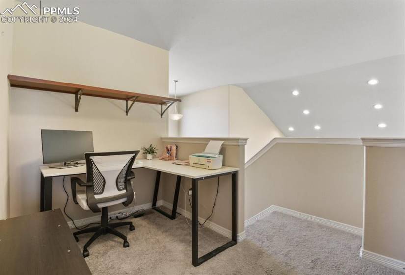 Carpeted home office featuring lofted ceiling