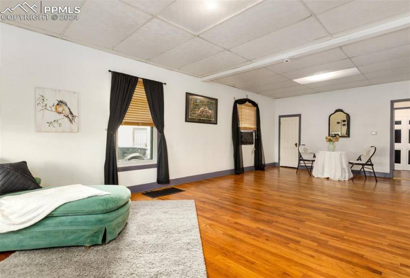 Bedroom with hardwood / wood-style flooring and a paneled ceiling