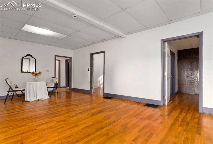Unfurnished room with a drop ceiling and hardwood / wood-style floors