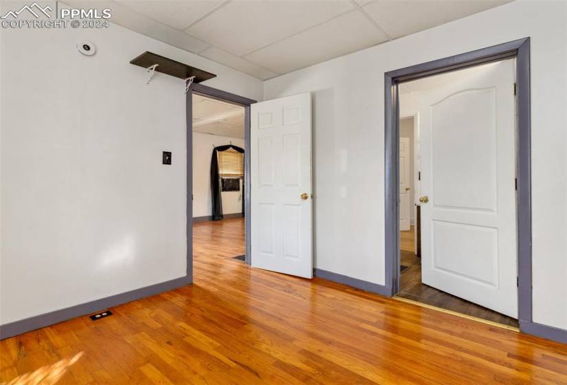 Spare room with light wood-type flooring and a drop ceiling