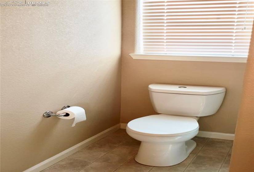 One of 3 bathrooms  with plenty of natural light, tile floors, and toilet