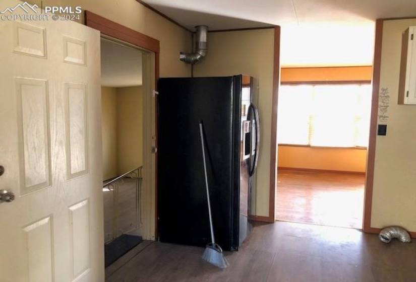 Kitchen featuring dark hardwood / wood-style flooring and black refrigerator with ice dispenser
