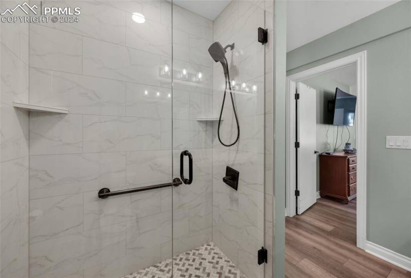 Bathroom featuring an enclosed shower and hardwood / wood-style flooring