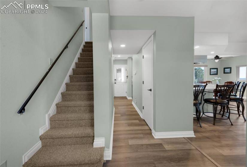 Stairs with hardwood / wood-style floors and ceiling fan