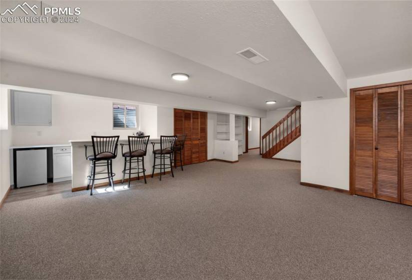 Basement with bar area and carpet flooring