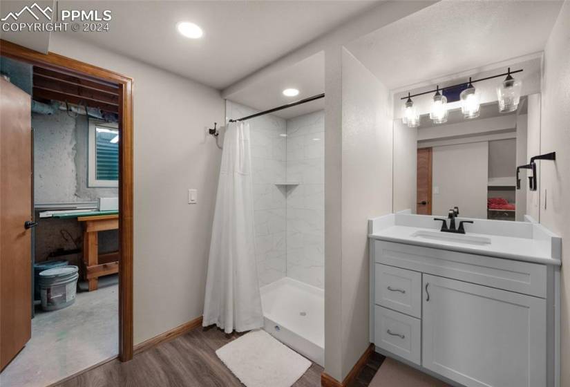 Bathroom featuring oversized vanity, a shower with curtain, and hardwood / wood-style floors