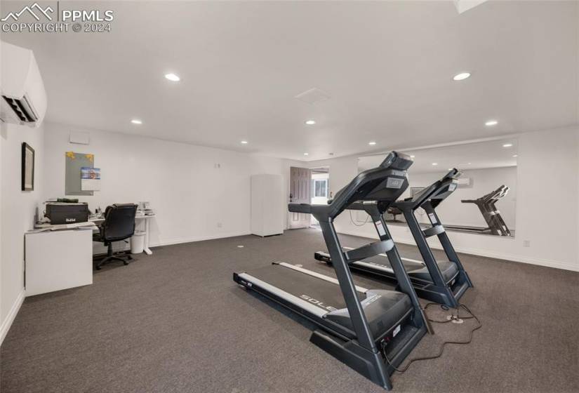 Workout room with a wall mounted AC and dark carpet
