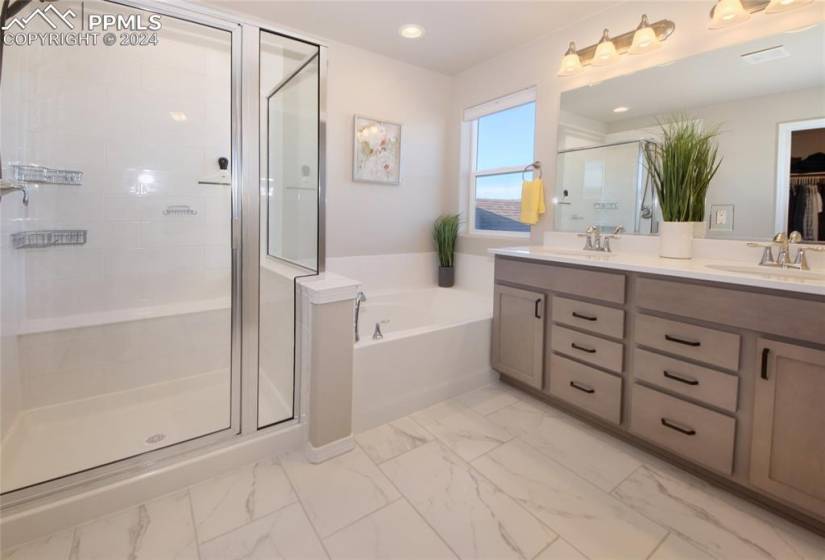 Bathroom featuring independent shower and bath, double sink vanity, and tile flooring