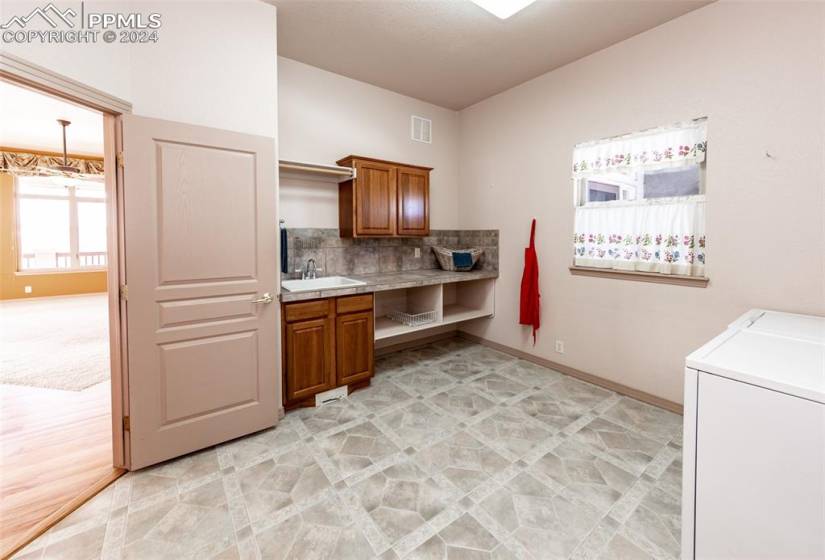 Main level 11x11 mud/laundry room with sink & storage cabinets