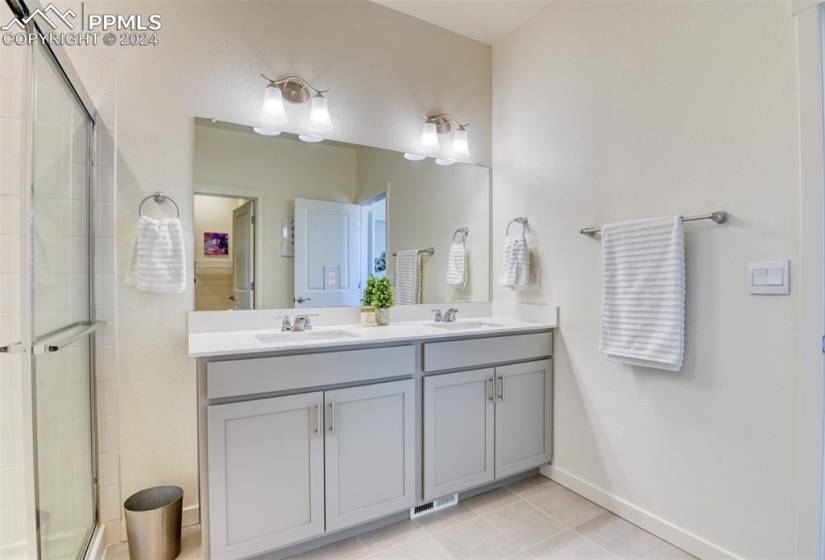 Bathroom featuring tile floors, dual sinks, and oversized vanity
