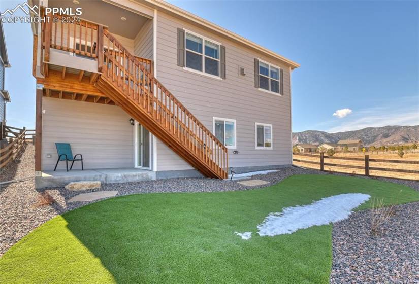 Rear view of property featuring a lawn, a patio area, and a mountain view