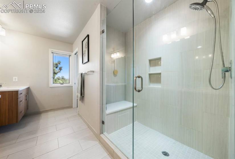 Bathroom with an enclosed shower, tile floors, and vanity