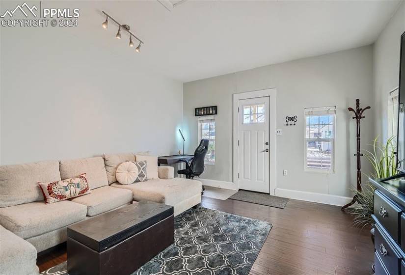 Living room with dark hardwood / wood-style floors and rail lighting