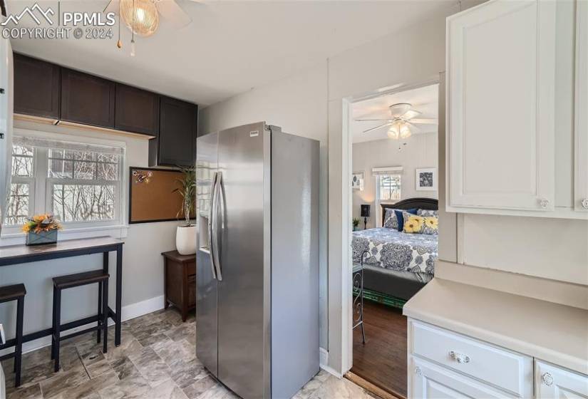 Kitchen featuring white cabinets, stainless steel refrigerator with ice dispenser, and ceiling fan