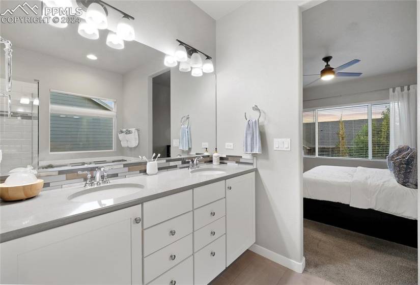 Bathroom featuring tile floors, large vanity, double sink, and ceiling fan