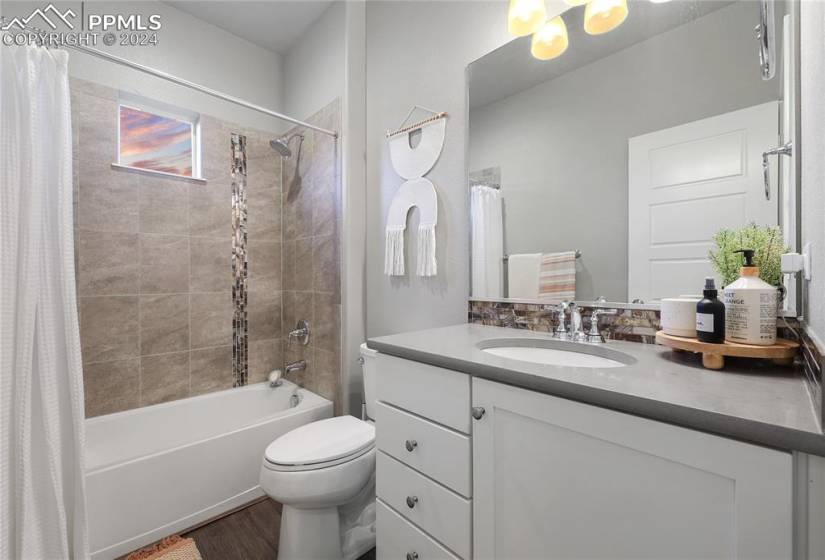 Full bathroom with toilet, vanity with extensive cabinet space, and shower / bath combo with shower curtain