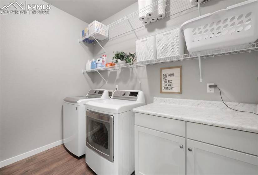 Washroom with cabinets, independent washer and dryer, and dark wood-type flooring