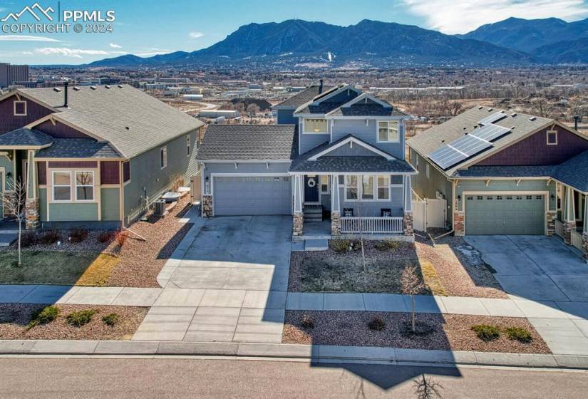 Craftsman inspired home featuring solar panels, a garage, a mountain view, and covered porch