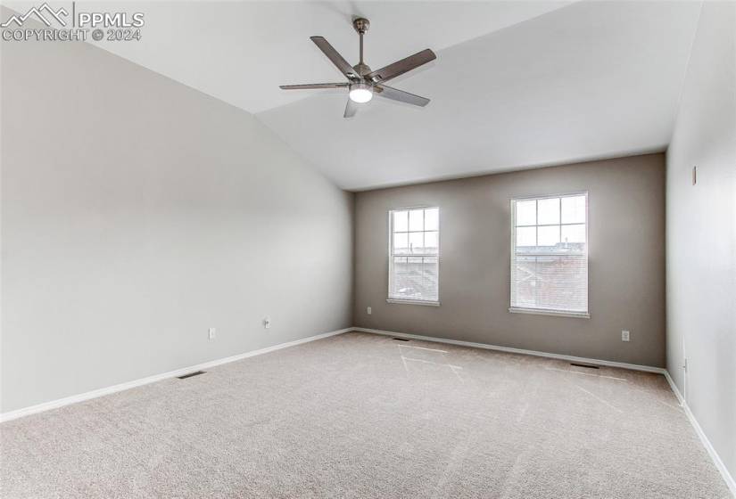 Unfurnished room with vaulted ceiling, light carpet, and ceiling fan
