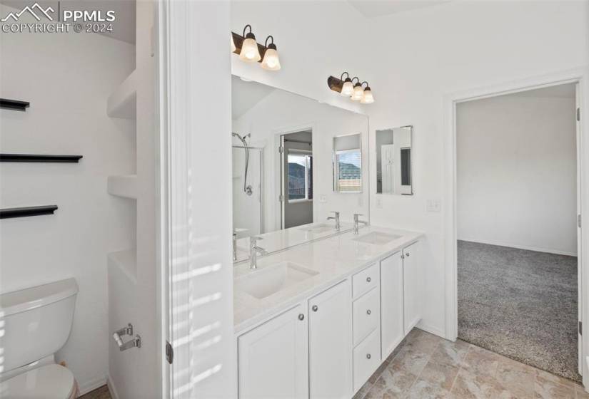 Bathroom featuring oversized vanity, tile floors, dual sinks, and toilet