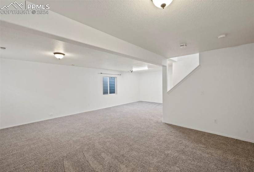 Basement with a textured ceiling and carpet