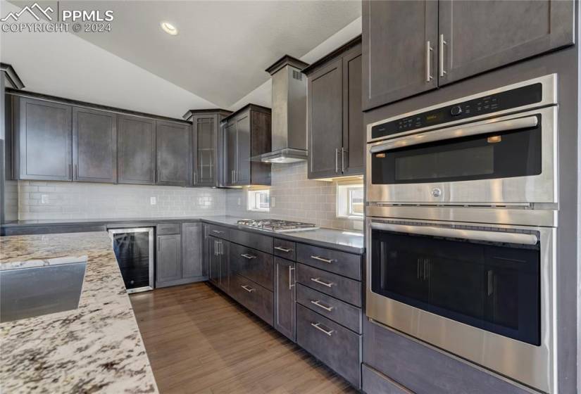Stainless Steel Appliances Include: 5-Burner Gas Cooktop, Wall Convection Oven + Microwave Combo, Dishwasher, Refrigerator, Wine Refrigerator + Hood Vent