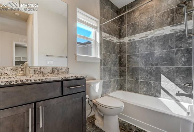 Main Level Full Bathroom | Granite Countertop | Tub/Shower Combo with Floor-to-Ceiling Tile Surround | Tile Floor