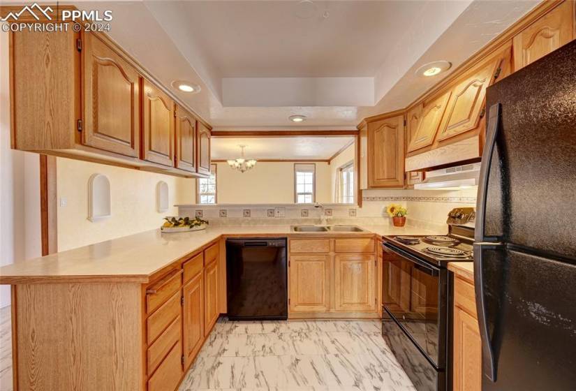 Great kitchen with black appliances, adjoining dining room with walk out to deck.
