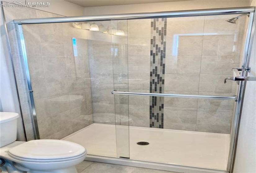 Roomy shower in the upper level master bath offers beautiful custom tile work.
