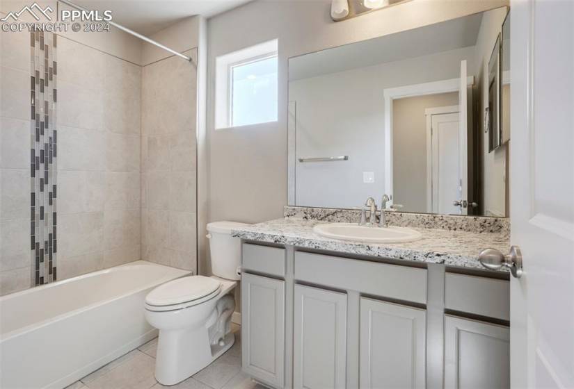 Upper level full hall bath features a granite vanity and tiled tub/shower surround.