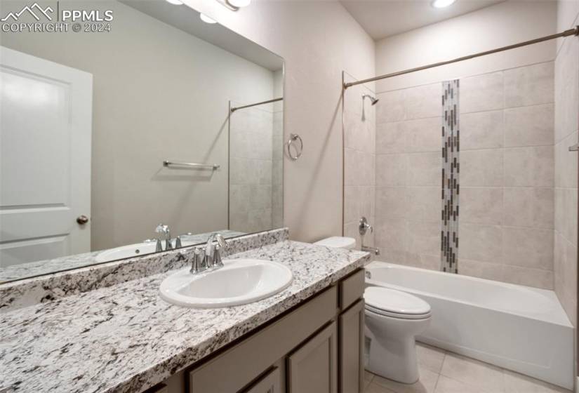 Basement full bath features a large granite vanity and beautifully tiled tub/shower surround.