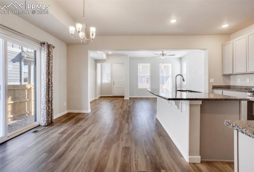 Open concept living, dining and kitchen features modern colors, granite counters and stainless appliances. Access to the yard is off the dining area and a powder room is nearby.