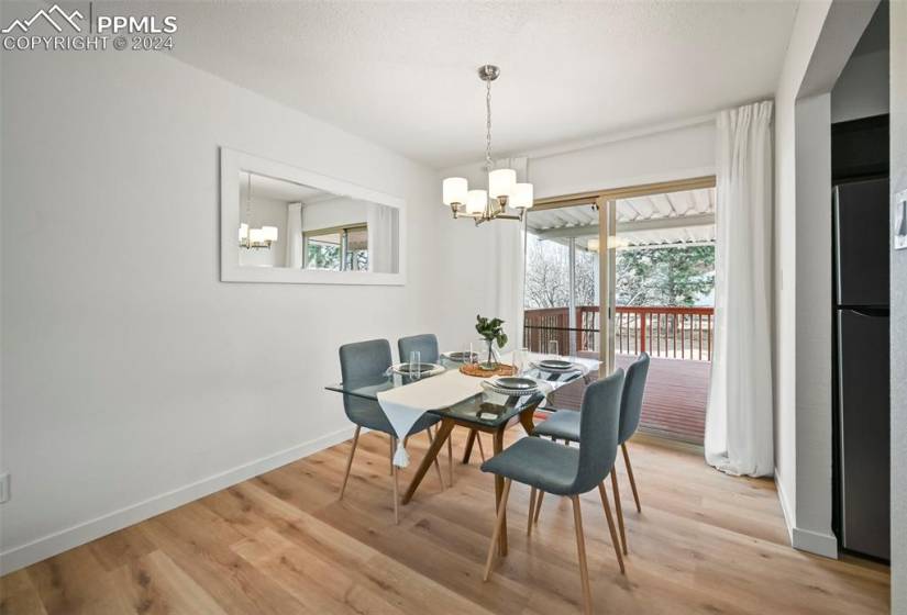 Dining room with a notable chandelier, light hardwood / wood-style floors, and plenty of natural light