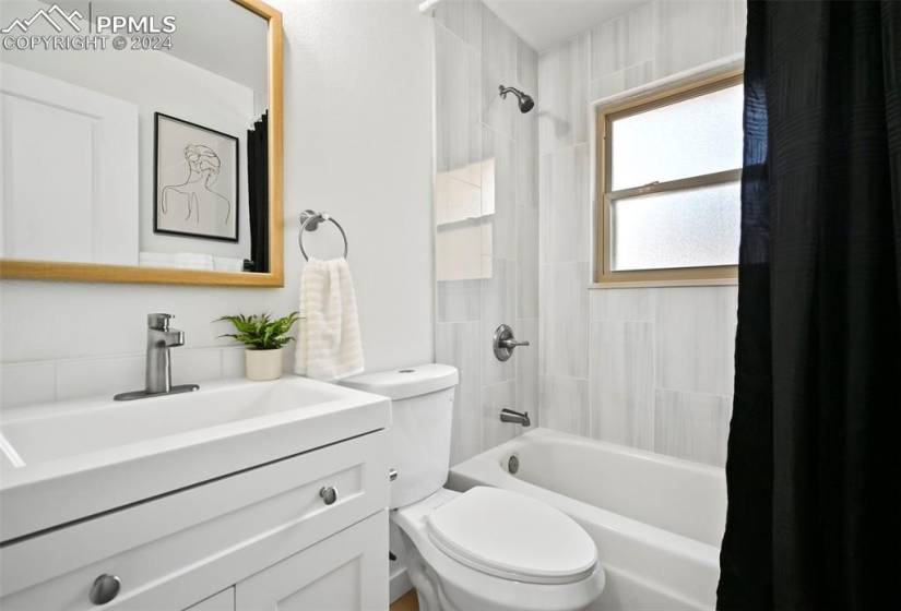 Full bathroom featuring vanity, toilet, and shower / bath combination with curtain